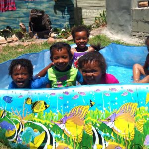 Children cooling off in the plastic swimming pool in the warm summer months